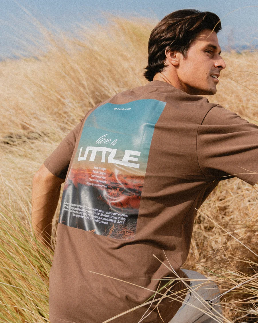 Live a Little graphic tee worn in sunlit grass